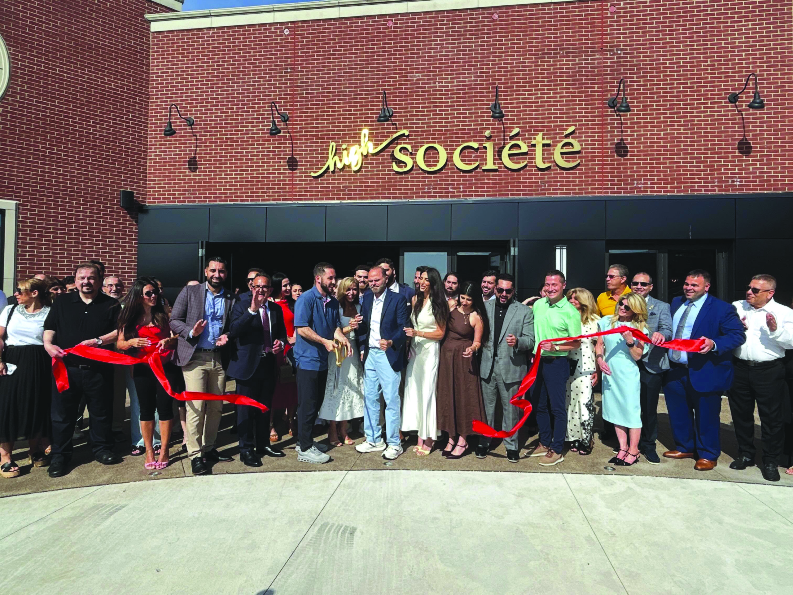Kasey Chammout joined by Mayor Abdullah Hammoud and other local officials and guests cuts the ribbon for his new High Société restaurant in Downtown West Dearborn on June 29.