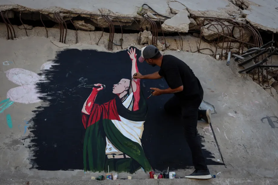 A Palestinian artist paints a mural of US rapper Macklemore on the wall of a destroyed house in Gaza City to thank him for expressing support for Palestinians in the Gaza Strip, Gaza, Palestine, on September 17. – Photo by Abdalhkem Abu Riash – Anadolu Agency
